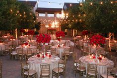 tables and chairs are set up for an event with lights strung over the top of them