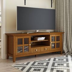 a flat screen tv sitting on top of a wooden entertainment center in a living room