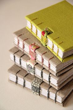 a stack of small books sitting next to each other on top of a white table