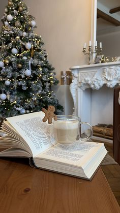 an open book with a gingerbread cookie on it next to a cup of coffee