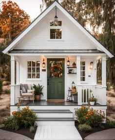 a white house with green front door and porch