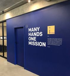 there is a sign on the wall that says many hands one mission in front of it