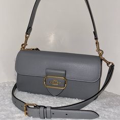 Coach Morgan Shoulder Bag New 100 % Authentic New With Packaging Granit Color With Gold Hardware Refined Pebble Leather Smooth Leather And Suede Snap Closure Handle With 9" Drop Strap With 21 1/4" Drop Included Approximately Measurements 10 1/2" L X 5 1/2" H X 2 1/2" W Smoke And Pets Free Scooter Bags, Crossbody Saddle Bag, Coach Crossbody Purse, Small Crossbody Purse, Black Leather Crossbody Bag, Bags Logo, Coach Crossbody Bag, Crossbody Messenger Bag, Leather Crossbody Purse