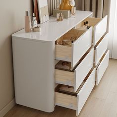 a white dresser with drawers and items on it