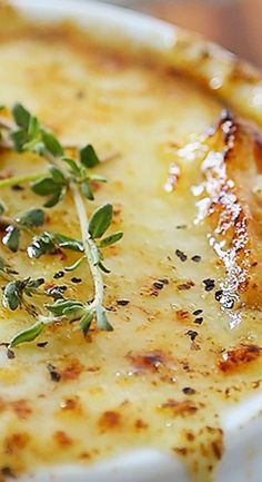 a close up of a plate of food with cheese and herbs