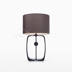 a table lamp with a black shade on it and a white wall in the background