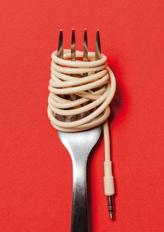 a white and black fork sitting on top of a red table