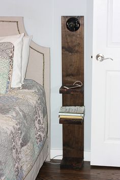 a bed with a wooden headboard and night stand in the corner next to it