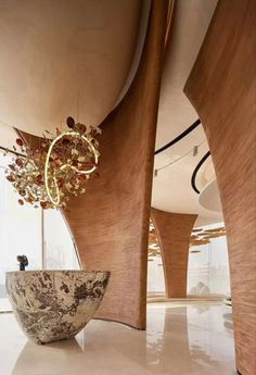 a large bowl sitting on top of a white floor next to a tall wooden structure