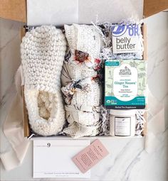 an open box containing white crocheted slippers and other items