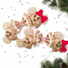 three brown mouse ears with red bows and numbers on them