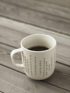 a cup of coffee sitting on top of a wooden table