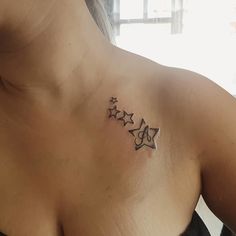 a woman's chest with three stars tattoo on her left shoulder and right breast