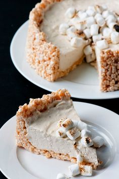 two plates with slices of pie on them and one slice has marshmallows