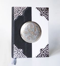 a white and black book with a silver medallion on it