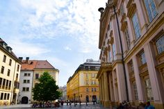 people are sitting on benches in the middle of an empty street with tall buildings behind them