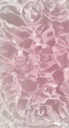 the water is very clear and pink in this photo, it looks like they are floating on