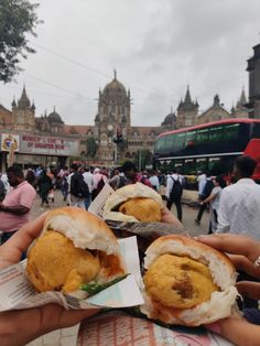 some people are holding sandwiches in their hands