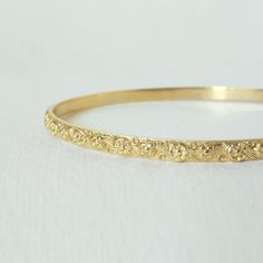 This vintage-inspired floral bangle is like wearing a mini-corsage on your wrist. An intricate romantic fluorish design, this vintage style bracelet is inspired by the femininity of the hand-engraved Victorian style. With its delicate details, it is a perfect bracelet band to wear alone, stacked for daily use, or to pair with our floral victorian ring.  Vermeil gold plating is much more durable than simple gold plating, as it deposits a 1-micron layer of pure gold on top of the silver.  Material: 925 Sterling Silver with 1 micron gold vermeil Internal width measures:  6 x 6.5cm (Medium) Thickness: 2.5mm Width: 4.5mm NOTES about our GOLD * Though we do not hallmark the insides of all our rings (it can interfere with the outside design), please be assured that items labeled as gold are made Heirloom Bracelets For Ceremonial Occasions, Dainty Engraved Bangle Jewelry, Victorian Bangle As Gift, Dainty 14k Gold Bangle For Wedding, Dainty Engraved Gold Bracelet For Wedding, Dainty Engraved Bangle Bracelets, Dainty Yellow Gold Bangle For Wedding, Yellow Gold Flower Bracelets For Wedding, Victorian Ceremonial Engraved Gold Bracelet