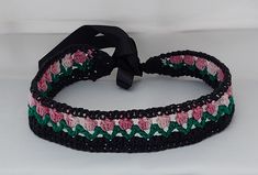 Crochet tulips headband. Knitted from cotton yarn. Handmade.  Three colors: Black, Dark green leaves and pink shades flowers. The ends have satin ribbons for tying at the back. Length of the knitted band: 45 cm Length of each ribbon on the side: 20 cm Total length: 85 cm Can be suitable for both children and adults. One size fits all. The band comes in different and varied colors. you can see some in the pictures here. Can be ordered in other colors. write to me. Crochet Headband Tulip, Black Spring Headband, Adjustable Black Handmade Headband, Adjustable Black Harajuku Headband, Adjustable Multicolor Crochet Headband, Headband Knitted, Adjustable Pink Crochet Headband, Headband Black, Pink Shades