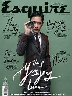 a man in a suit holding a camera up to his face on the cover of esqquite magazine