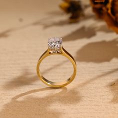 a close up of a ring with a flower in the background