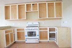 a white stove top oven sitting inside of a kitchen next to wooden cupboards and drawers