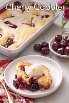 a cherry cobbler on a plate with ice cream and cherries in the background