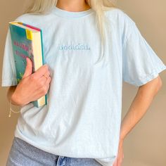 Monochromic and incredibly comfy, this bookish embroidered tee features light blue thread on a chambray Comfort Colors tee. They're high quality & made to last with a soft, vintage look and feel! You will not want to take it off. Features 100% ring spun cotton Soft washed garment dyed fabric Tee runs slightly big and has a wide boxy throw-back 90s style cut For size guide, view comfort colors tee Spring Cotton T-shirt With Bookish Style, Bookish Shirts, Bookish Merch, Take It Off, Embroidered Tee, Comfort Colors Tee, 90s Style, Feature Light, Dyed Fabric