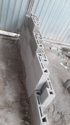 a pile of cement blocks sitting on top of a dirt field next to a building