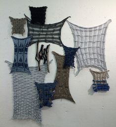 several pieces of fabric hanging on the wall