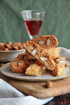 almond bars stacked on top of each other next to a cup of tea and bowl of nuts