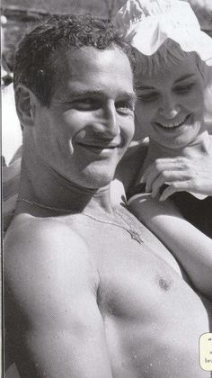 black and white photograph of man and woman on beach towel with others in the background