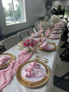 the table is set with pink napkins and place settings