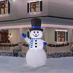 a snowman is standing in front of a house