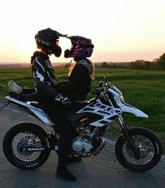 a man and woman sitting on a motorcycle