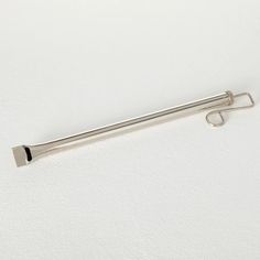 a metal object on a white surface with a hook in the middle that is attached to it