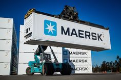 a forklift is parked in front of a large sign that reads maersk