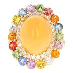 6.52 Carat Opal Rainbow Sapphire Yellow Gold Statement Ring  This stunning statement ring features a 6.52-carat cabochon-cut natural opal with a vibrant orange hue and dazzling play of color, a hallmark of high-quality opals. Surrounding the opal are 2.60 carats of round-cut natural rainbow sapphires, complemented by 0.53 carats of natural diamonds with SI1 clarity and F color, bringing the total carat weight to an impressive 9.65 carats. Crafted in 14k yellow gold and weighing 8.0 grams, this elegant ring is a size 7 and can be resized for the perfect fit. The opal, measuring 14 mm x 11 mm, is sourced from Ethiopia, adding a touch of uniqueness to this extraordinary piece.   -Features a 6.52-carat cabochon-cut natural opal with a vibrant orange hue and rich play of color. -Encircled by 2. Yellow Gold Cocktail Ring, Rainbow Sapphires, Gold Statement Ring, Gold Cocktail Ring, Gold Cocktail, Natural Rainbow, Elegant Ring, Multi Stone Ring, Vibrant Orange