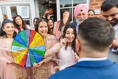 a group of people standing around each other with a wheel of fortune in front of them