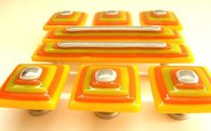 an assortment of orange and yellow glass knobs on wheels with holes in the middle