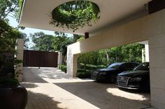 two cars parked in front of a house with trees on the other side of it