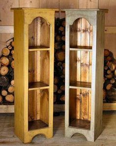 two wooden bookshelves sitting next to each other on top of a floor covered in logs