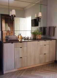 a bathroom with wooden cabinets and mirrors on the wall