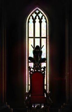 a red chair sitting in front of a stained glass window with a bird on it