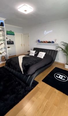 a bed room with a neatly made bed and black rugs