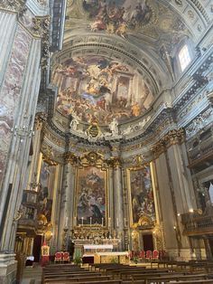 the inside of a church with people standing in front of it and paintings on the walls