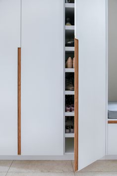 an open closet door with shoes and other items in the cupboards on either side