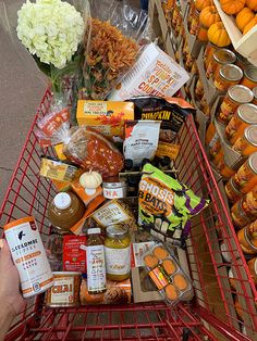 a shopping cart filled with lots of food and condiments on top of it