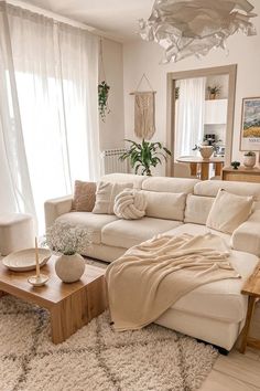 a living room filled with furniture and a large window covered in white curtained drapes